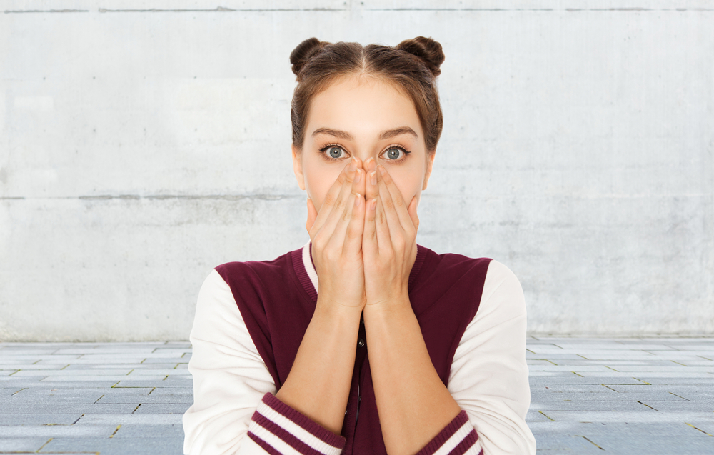 Shocked girl covering her mouth with hands outside