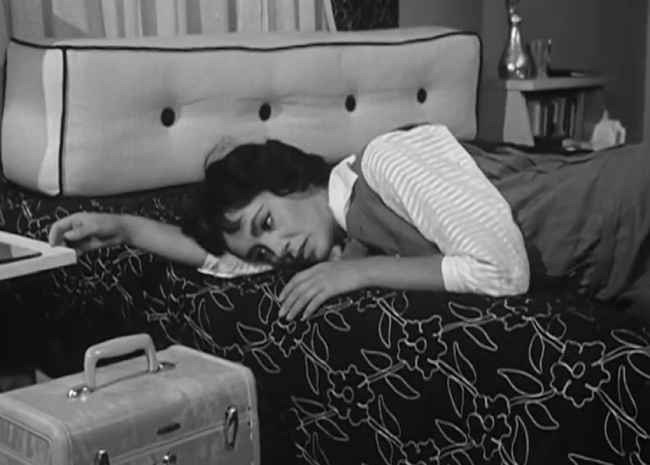 Screenshot: Susan Cabot is laying on the bed with sad face - from Sorority Girl (1957).