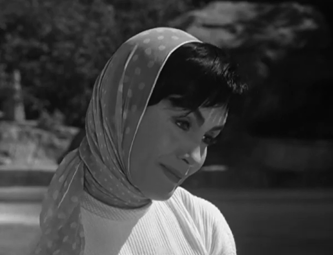 Screenshot: Susan Cabot wearing scurf on her head is looking happy outside - from Sorority Girl (1957).