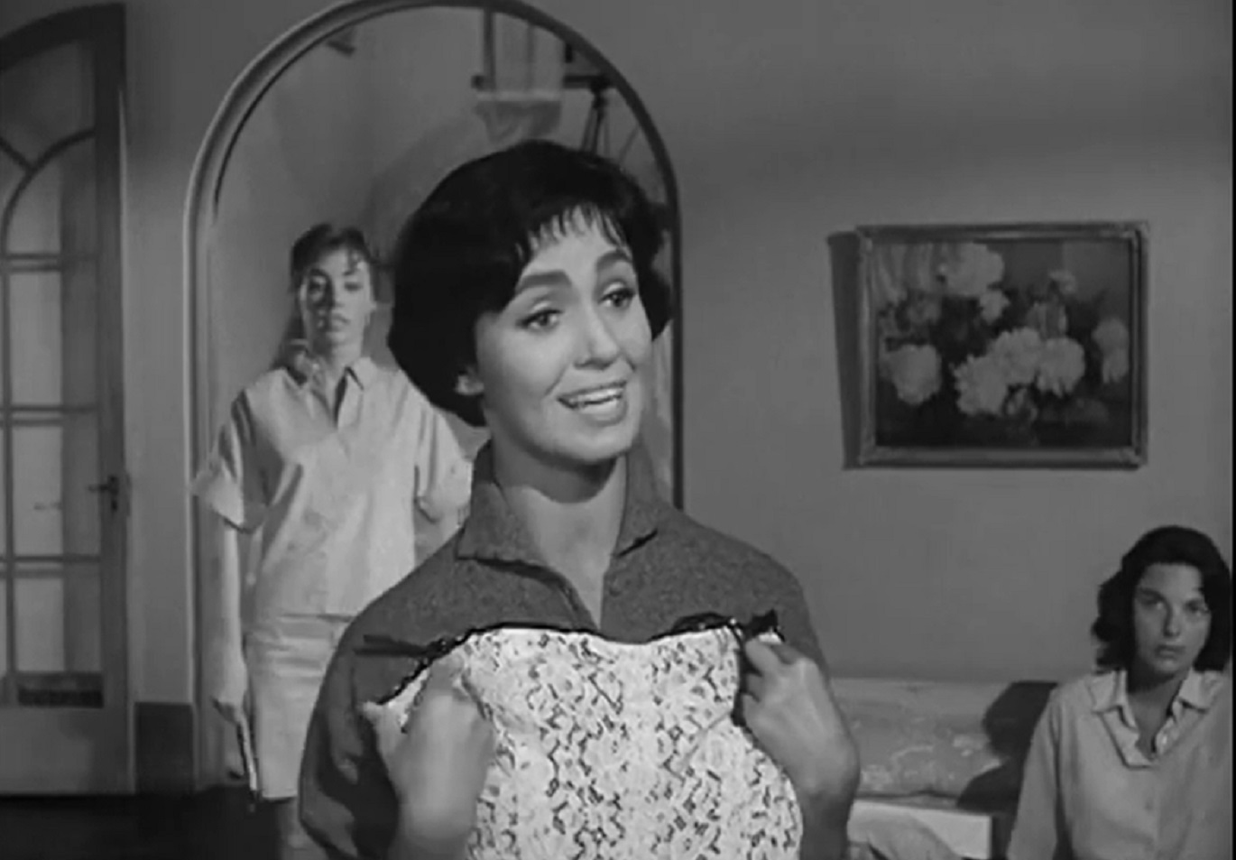 Screenshot: Susan Cabot is holding a white dress in hands and speaking - from  Sorority Girl (1957).