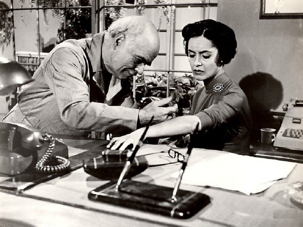 Susan Cabot is seating at desk and getting injection - from Wasp Woman (1959)
