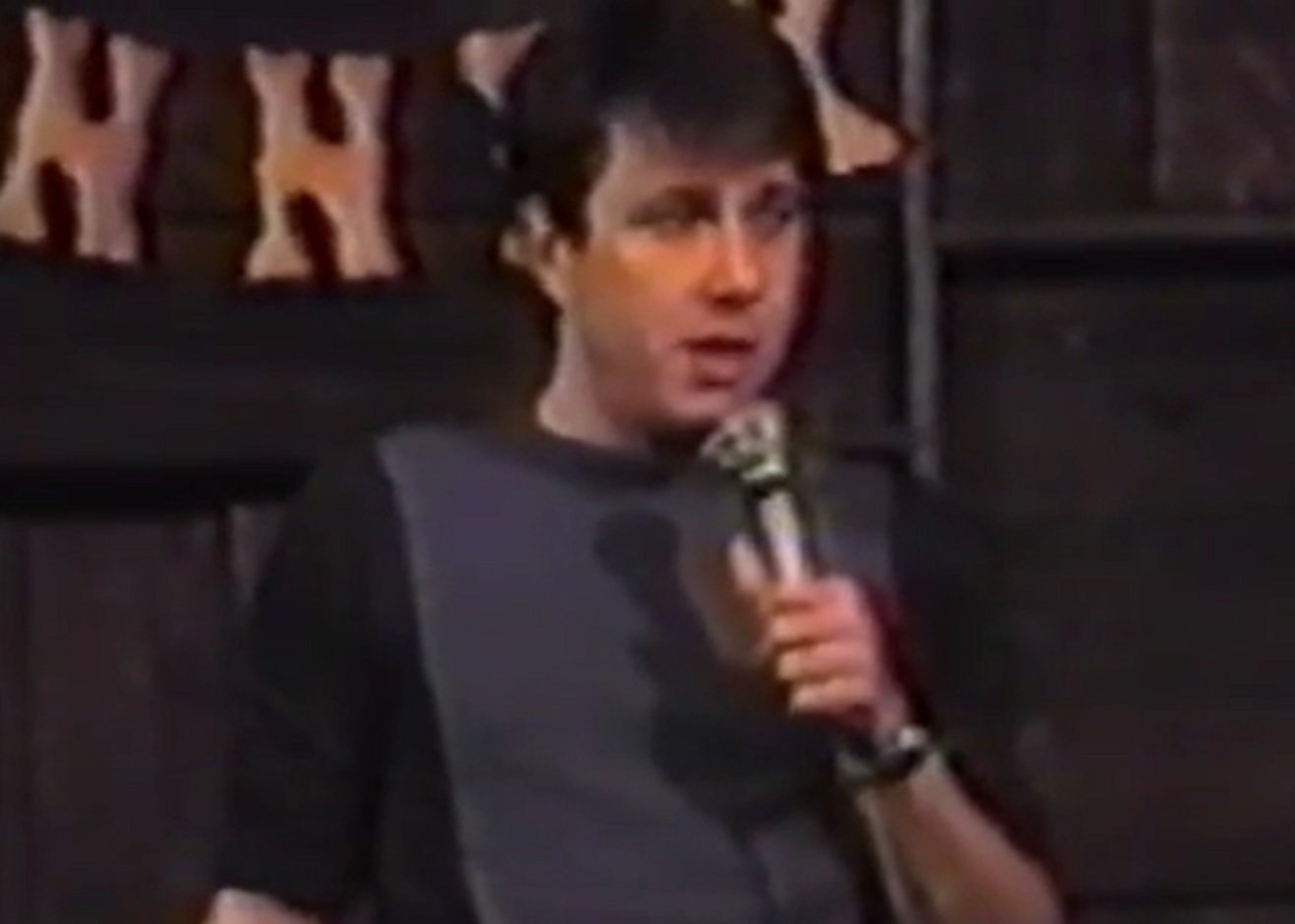 Screenshot: Young Bill Hicks is holding a microphone on stage - from American- The Bill Hicks Story (2009)