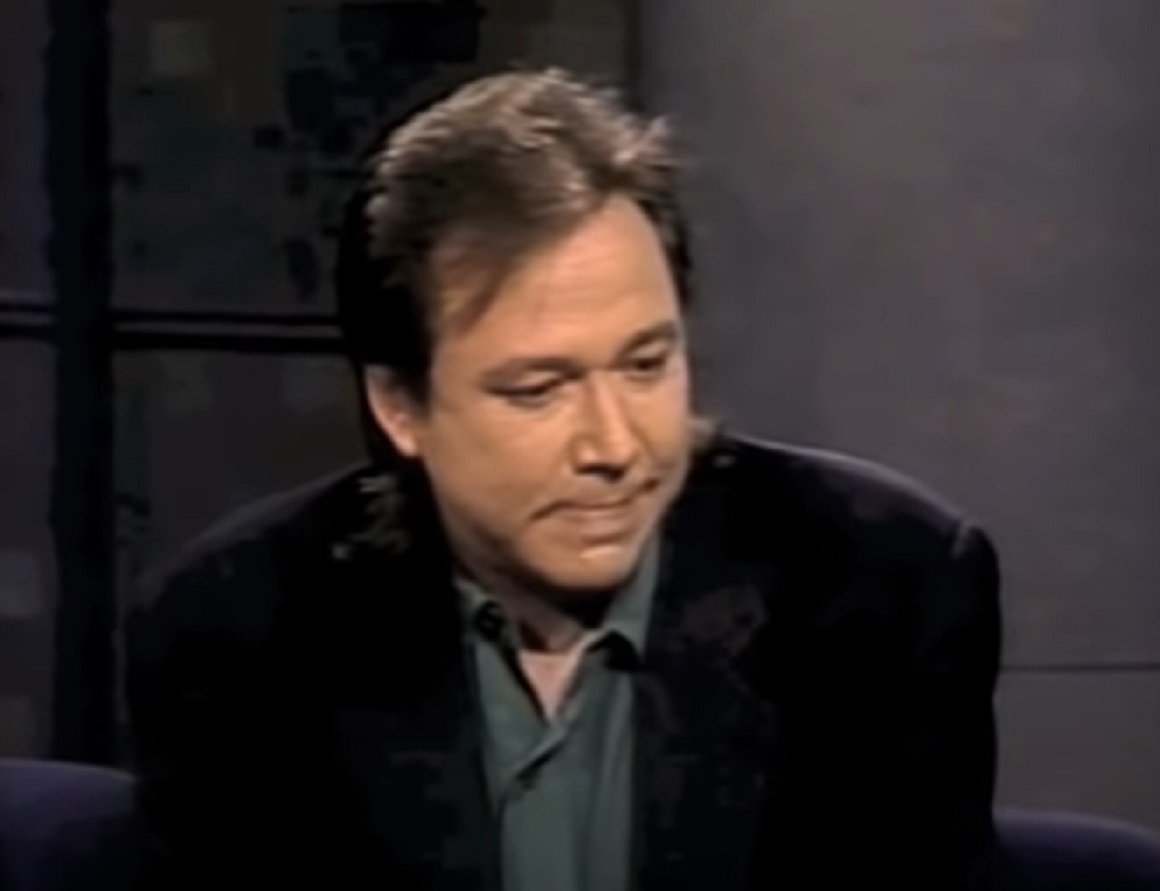 Screenshot: Bill Hicks wearing green shirt and black jacket is seating - from Late Night With David Letterman (1982-93)