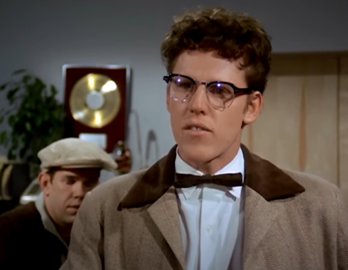 Screenshot: Buddy Holly wearing brown suit is looking at side - from The Buddy Holly Story (1978)