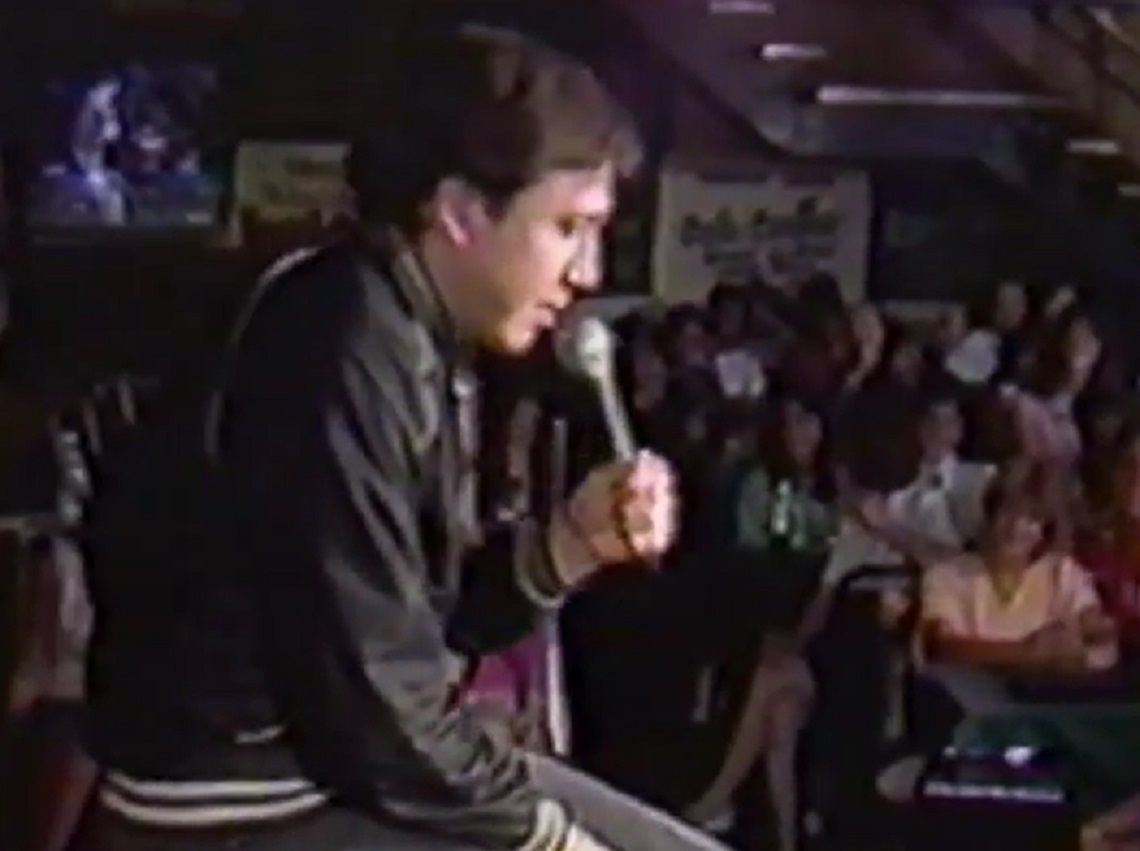 Screenshot: Bill Hicks is performing on stage - from American- The Bill Hicks Story (2009)