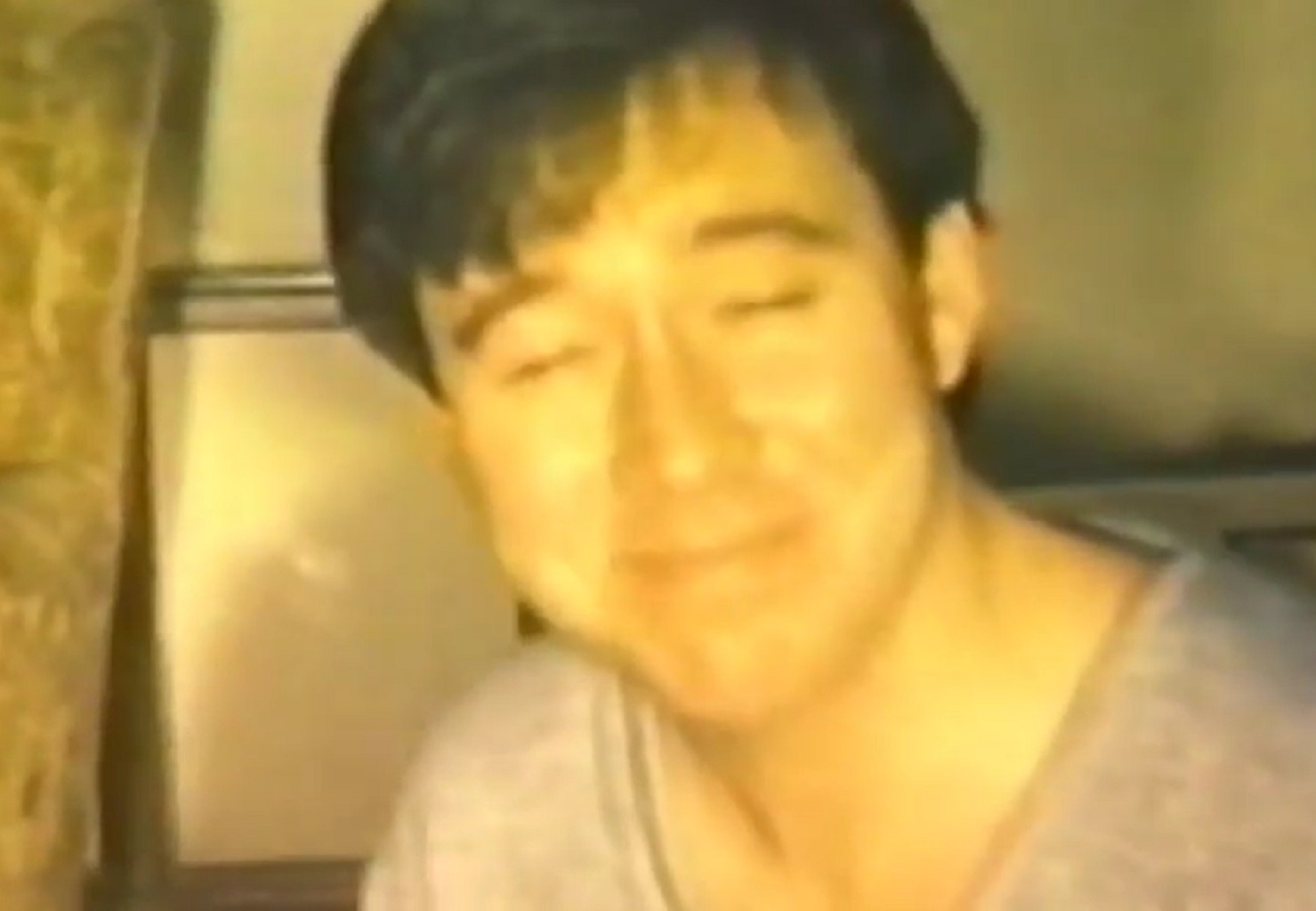 Screenshot: Bill Hicks is standing with closed eyes and smiling - from American- The Bill Hicks Story (2009).