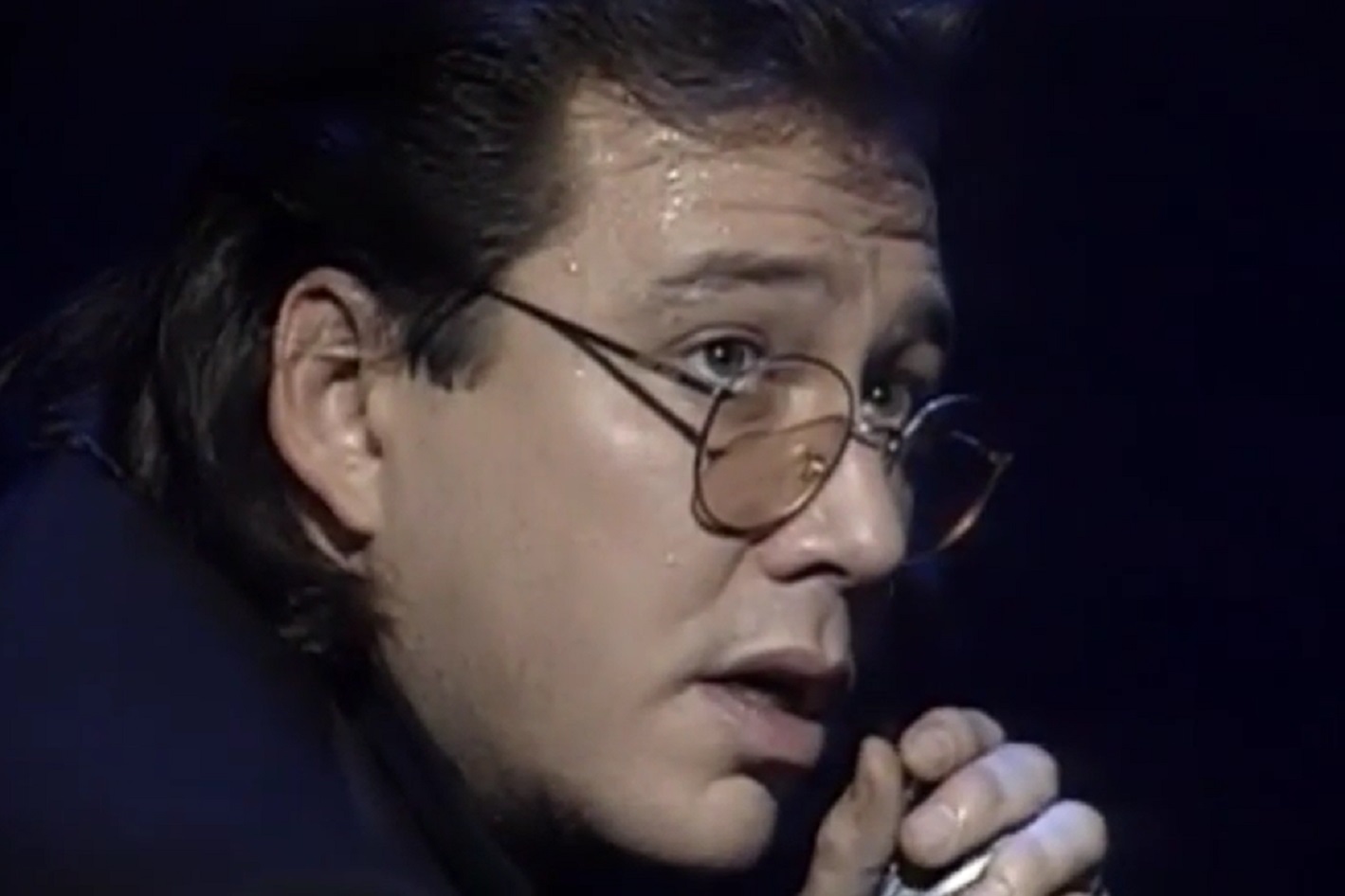 Screenshot: Bill Hicks wearing glasses is looking at side - from American- The Bill Hicks Story (2009)