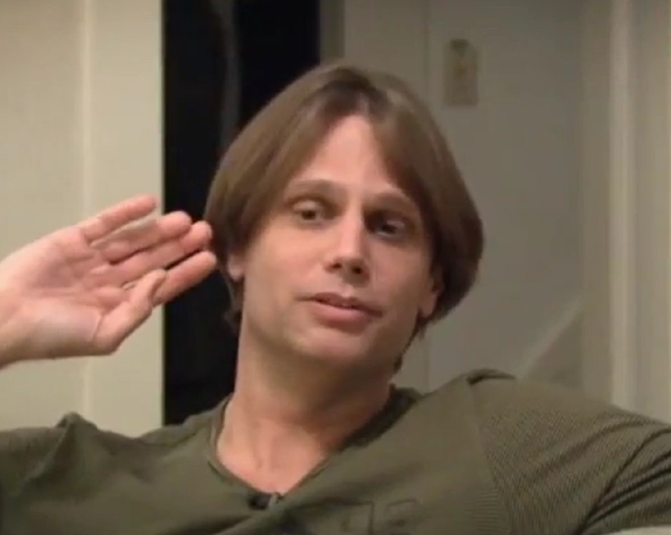 Screenshot: Dwight Slade seating and talking to camera - from American: The Bill Hicks Story (2009)