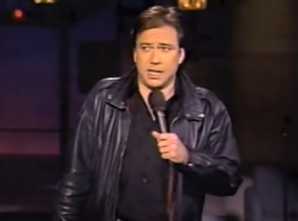Screenshot: Bill Hicks wearing black leather jacket is performing - from Late Night With David Letterman (1982-93).