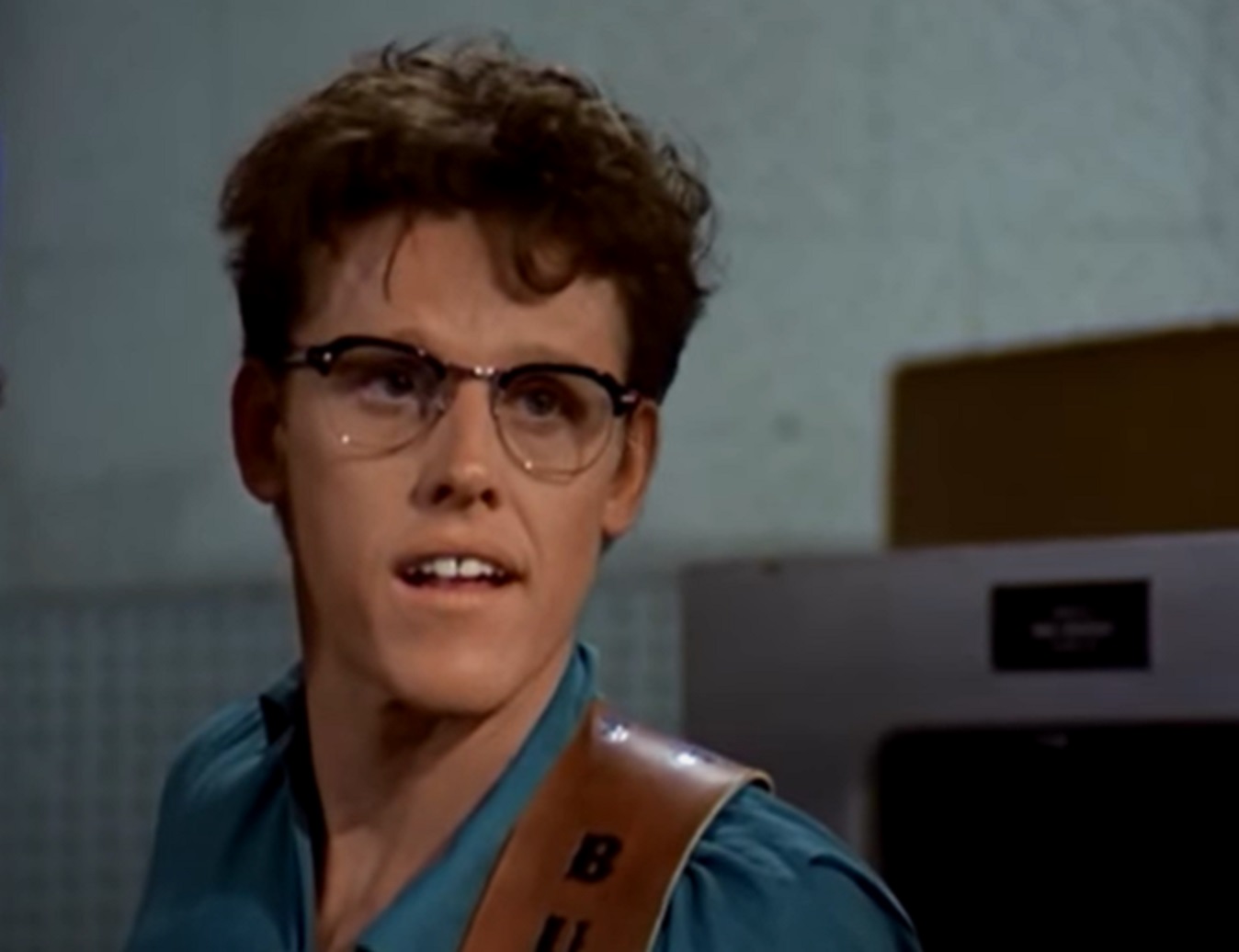 Screenshot: Buddy Holly wearing blue shirt is looking at side - from The Buddy Holly Story (1978)