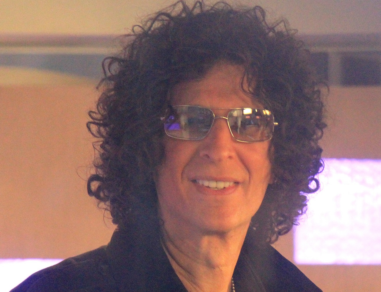 Howard Stern wearing sunglasses is smiling at camera - 2012