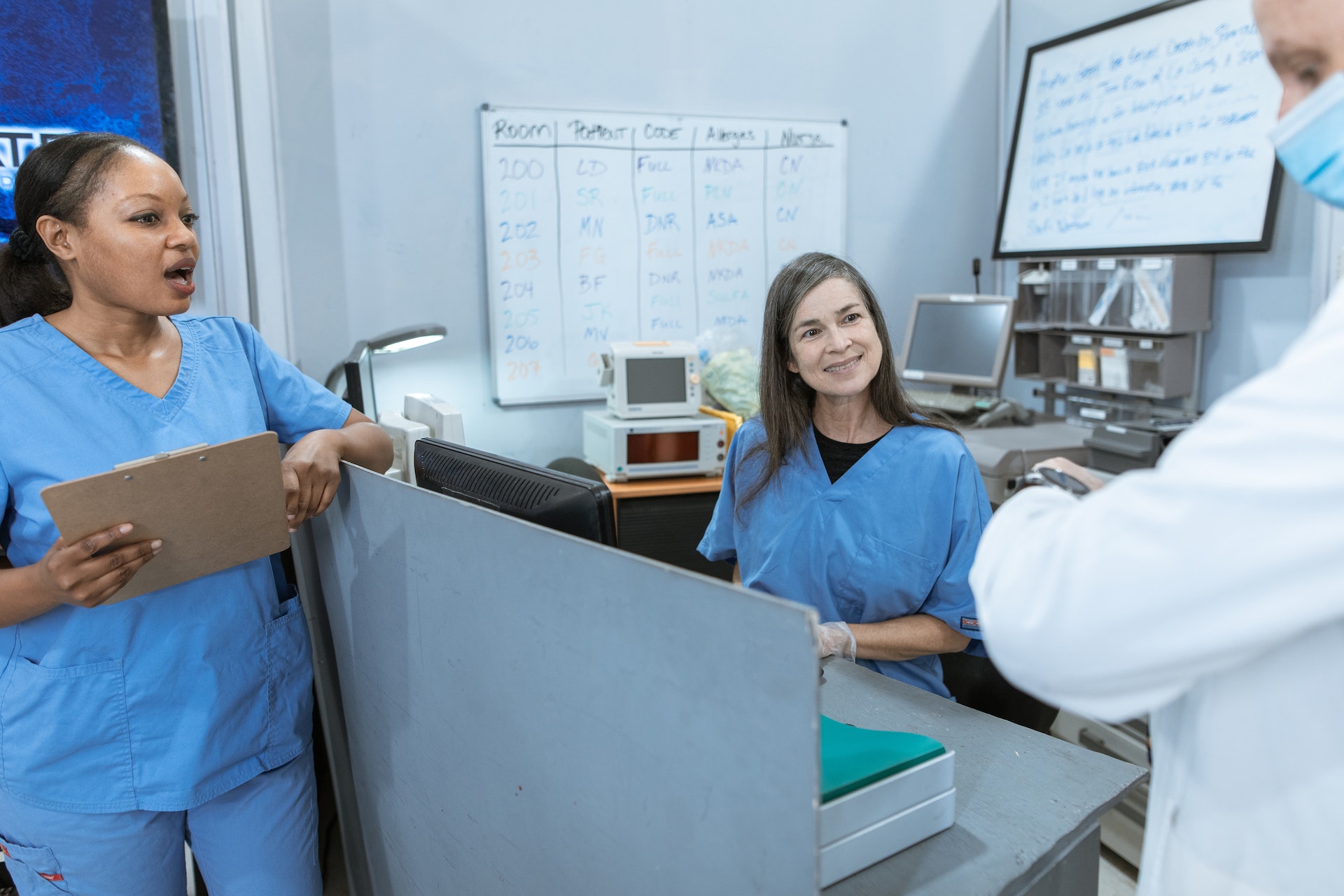 A Doctor and Nurses having Conversation on an office desk