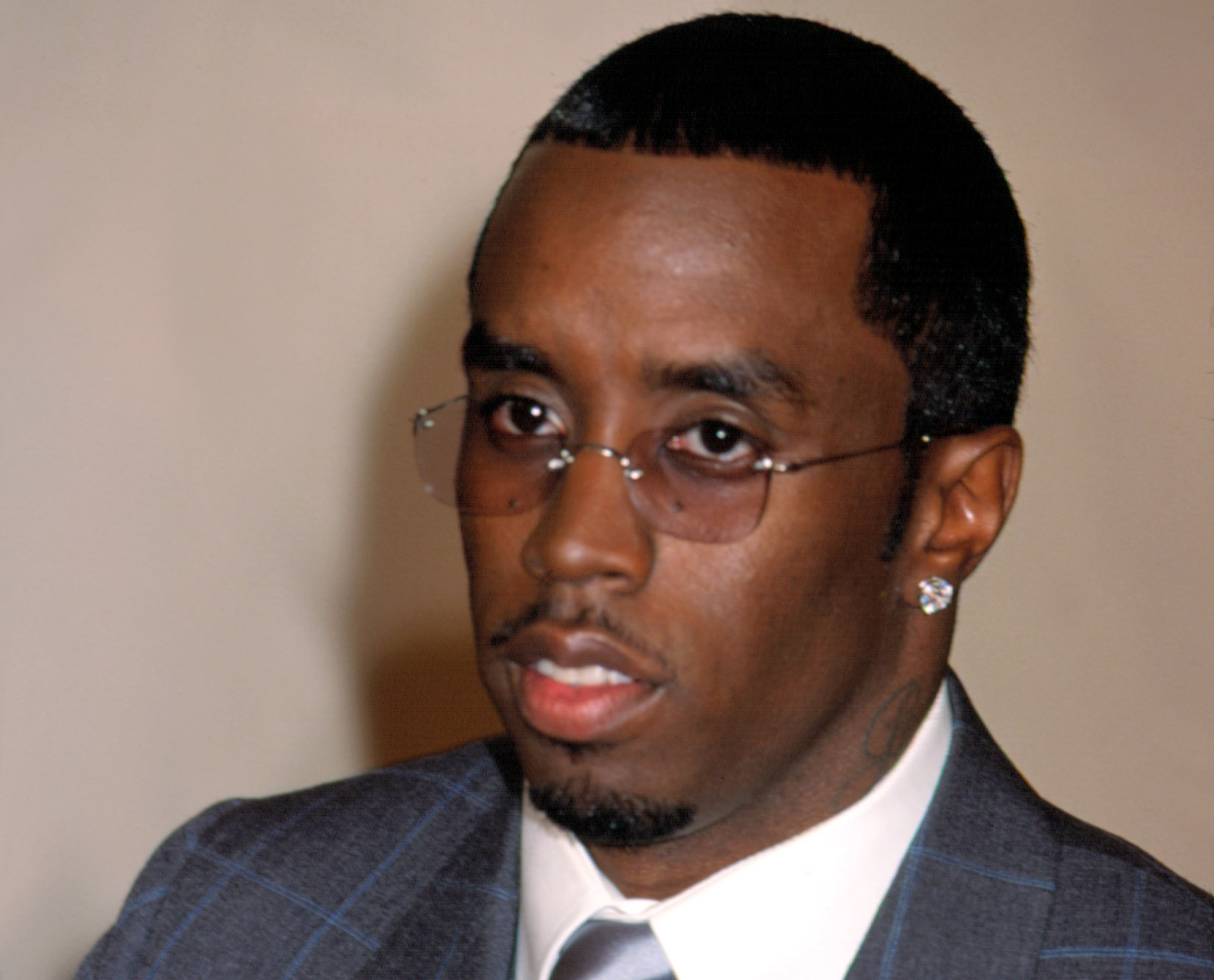 Sean 'Puffy' Combs in suit looking at camera