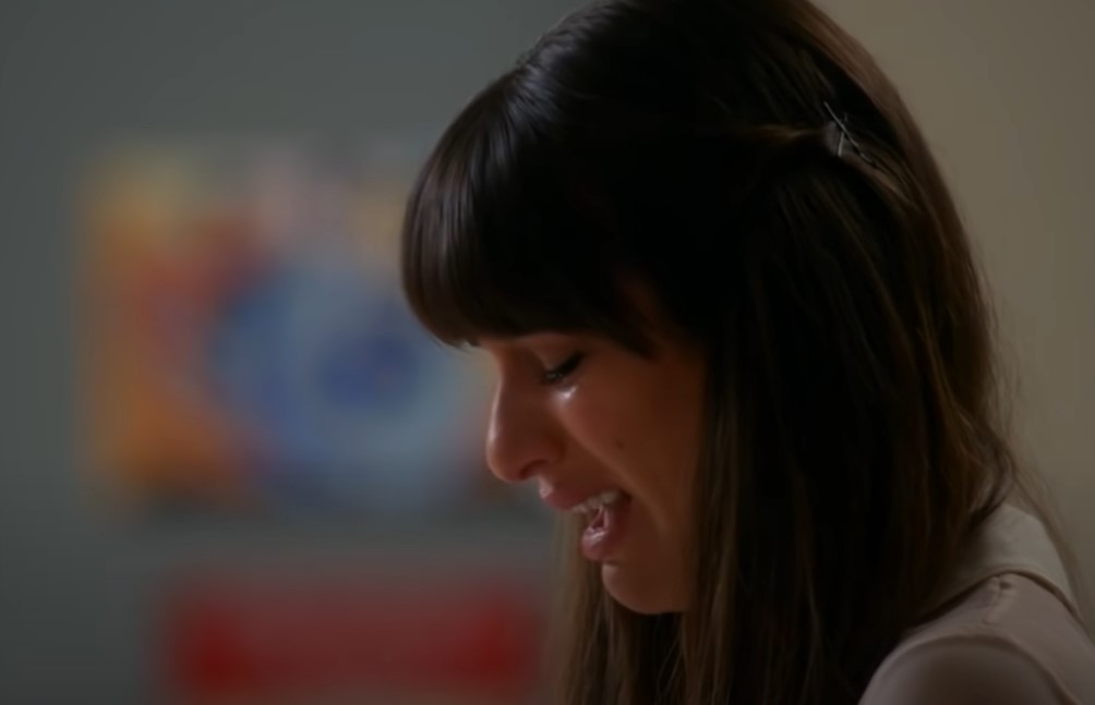 Lea Michele as Rachel Berry in white top crying and singing