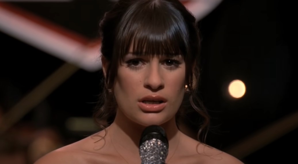 Lea Michele as Rachel Berry singing at stage wearing earring