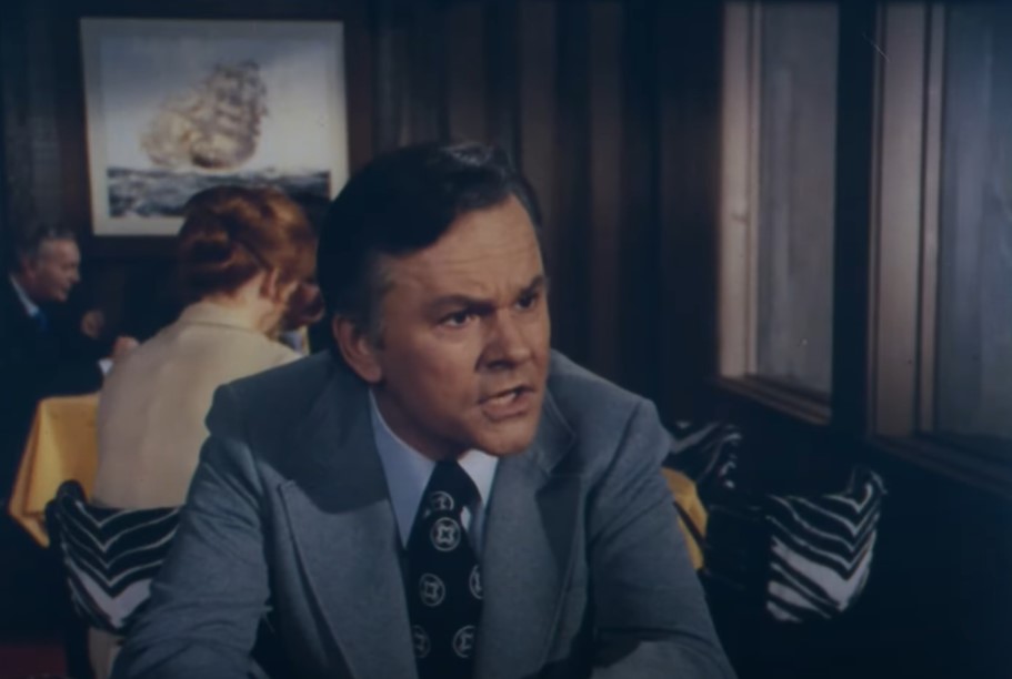 Bob Crane As Charlie McCready in suit sitting at a table
