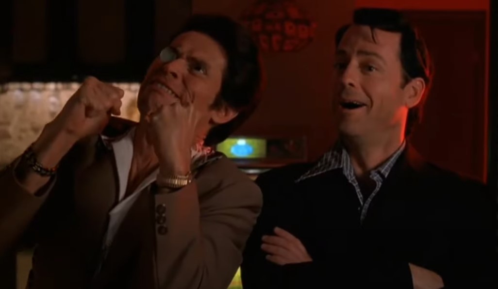 Willem Dafoe  as John Carpenter and Greg Kinnear  as  Bob Crane speaking to each other in dark place in suits