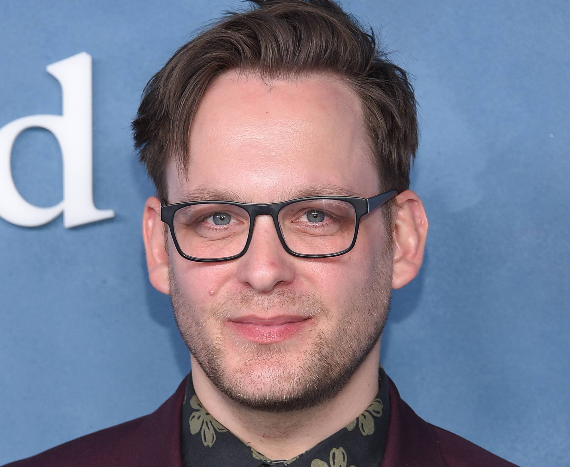 Theo Stockman in purple jacket and glasses