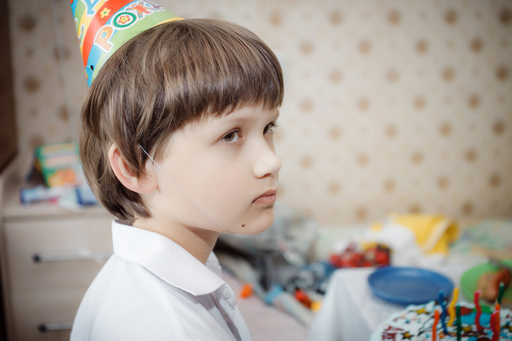 sad little boy on his birthday in white shirt