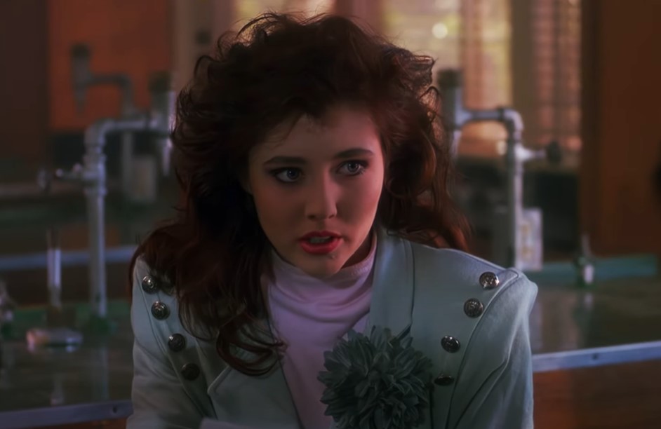 Shannen Doherty  in Heathers wearing mint green jacket looking at the camera