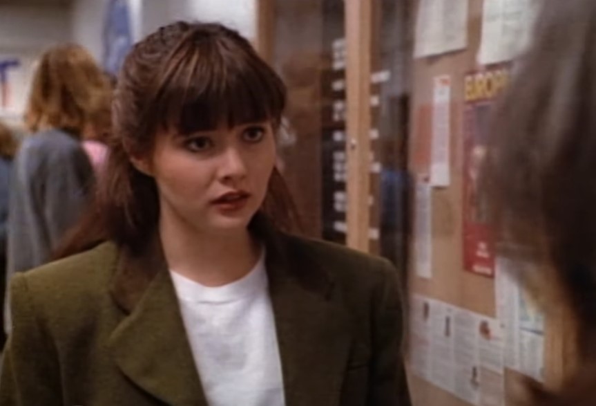 Shannen Doherty as Brenda Walsh in green jacket