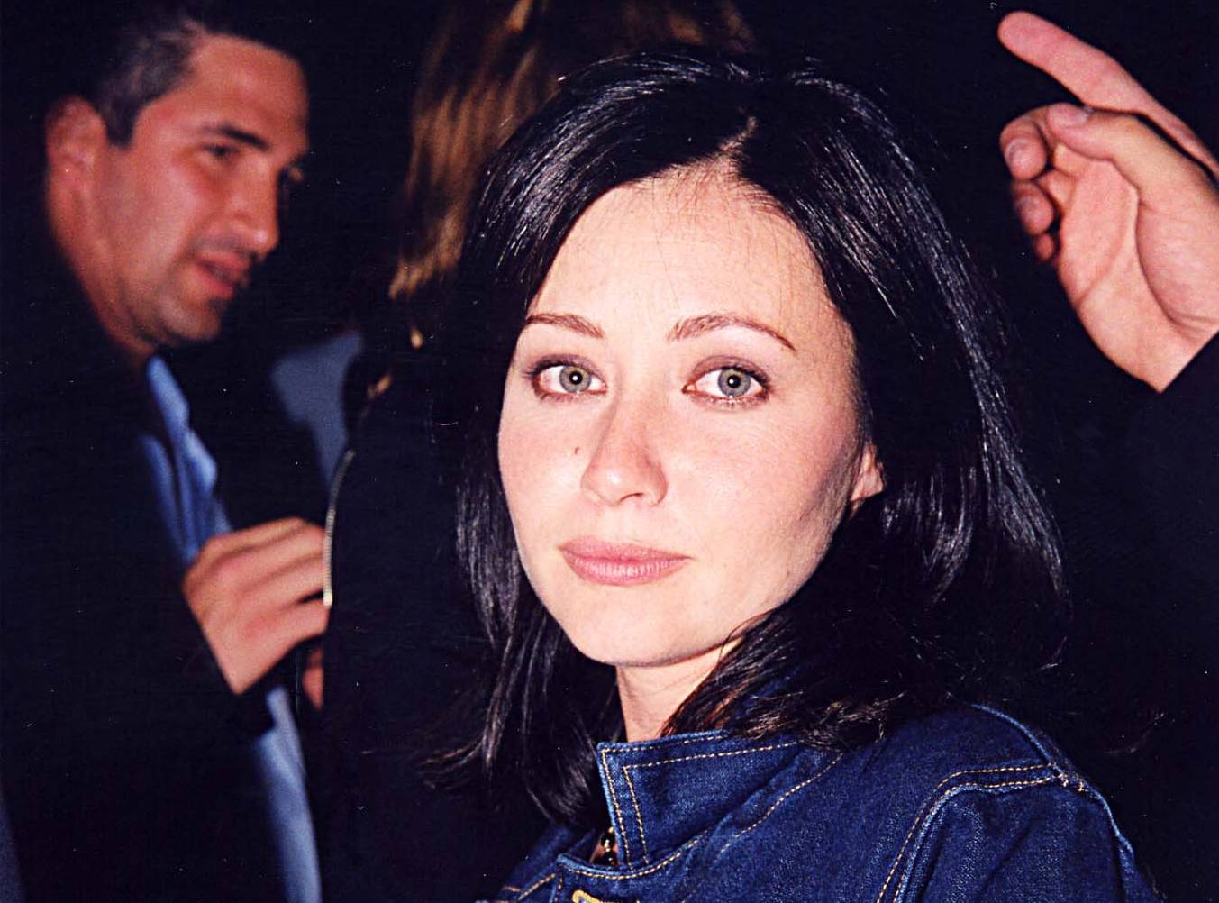 shannen doherty in jeans jacket looking at the camera