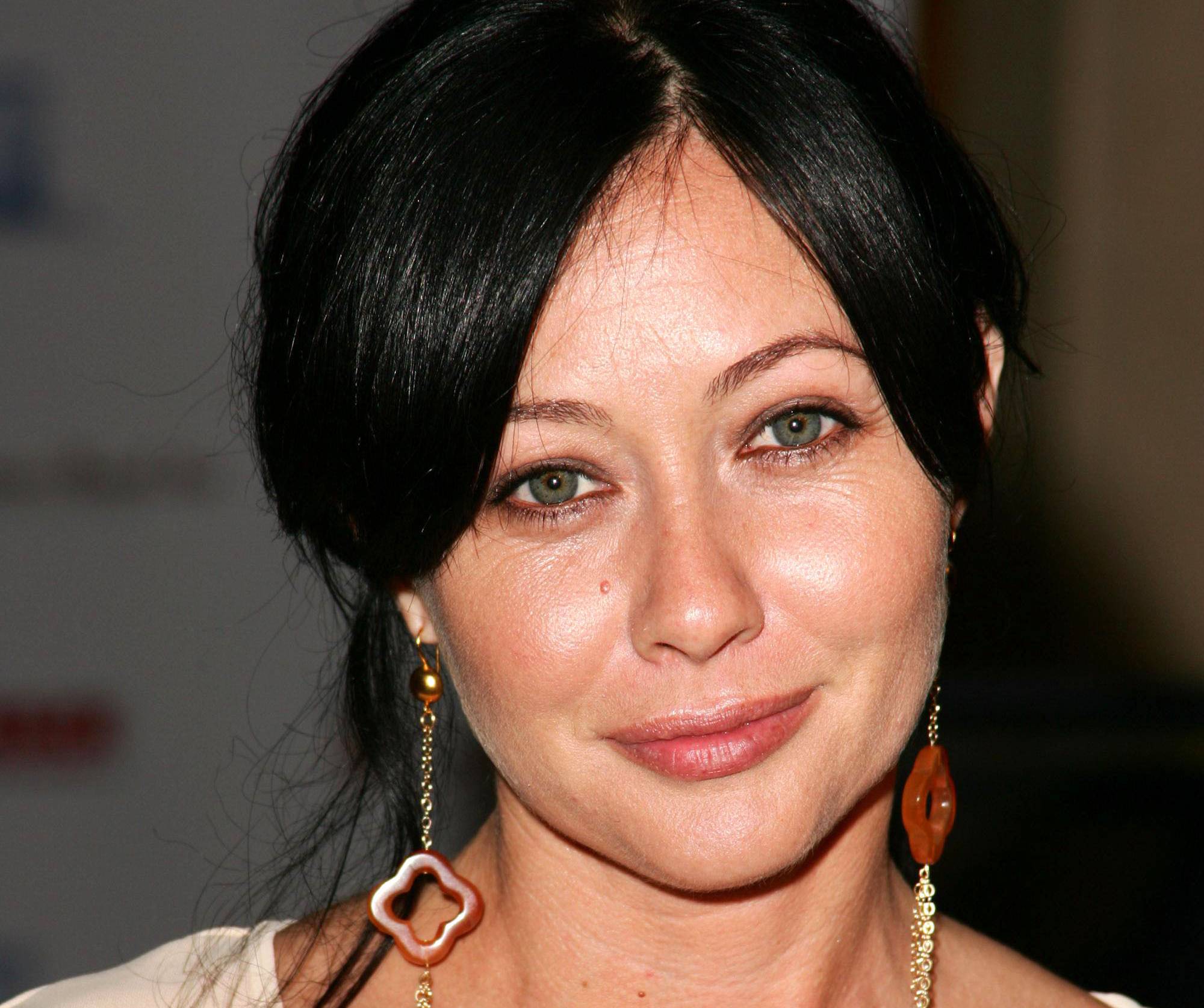 Shannen Doherty in white top and earrings