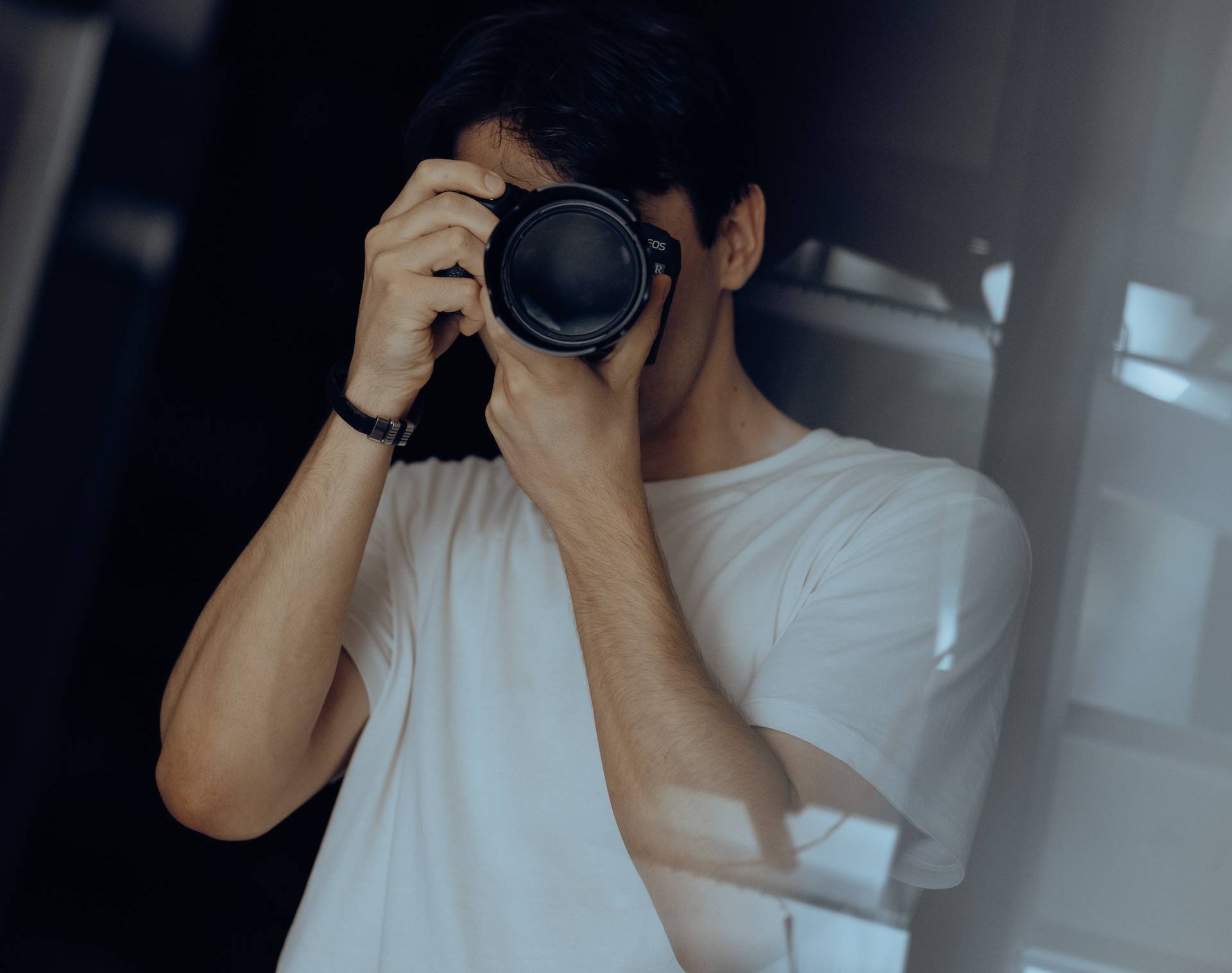 Man in white t-shirt taking a photo