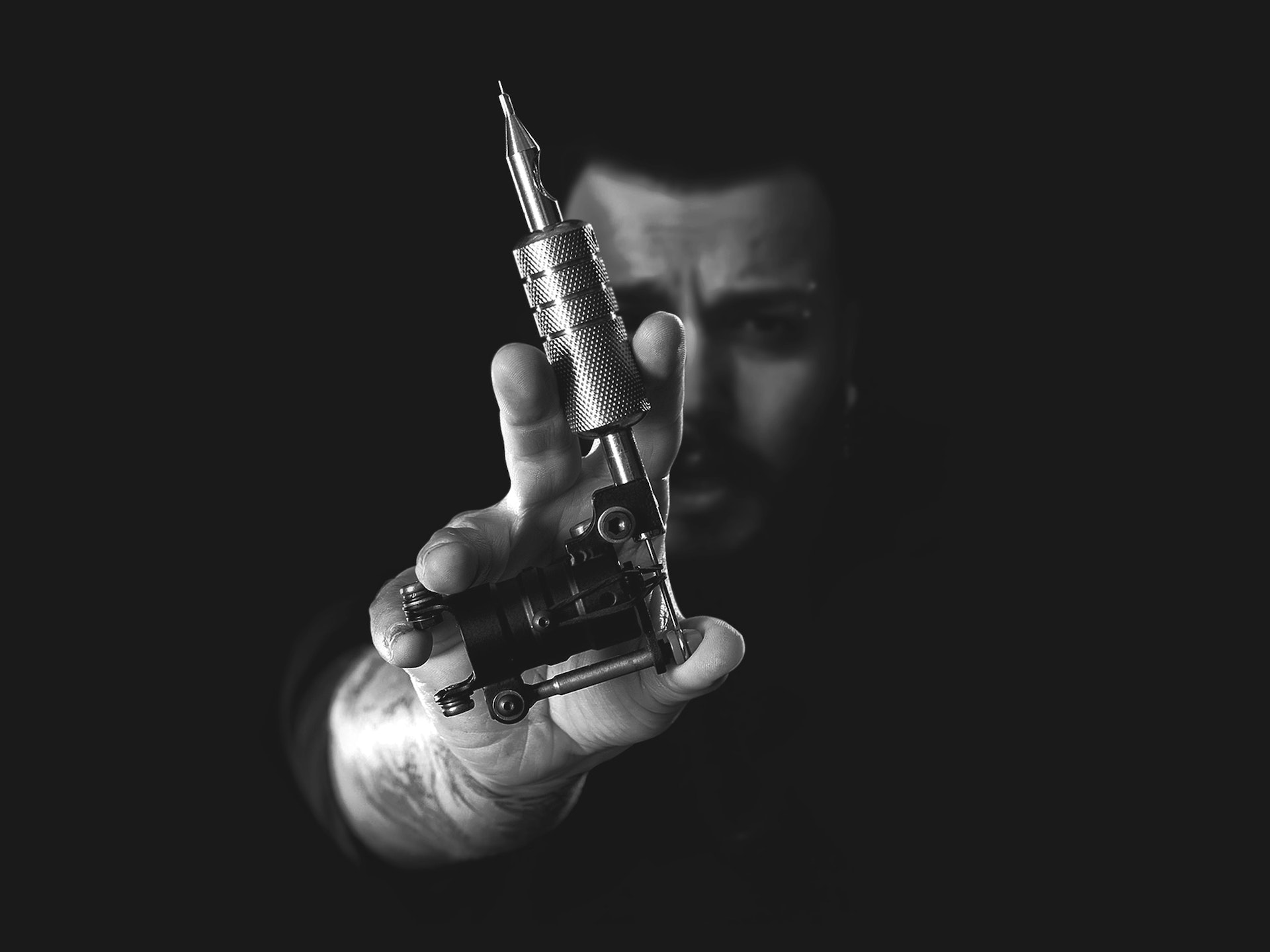 person holding a tattoo machine