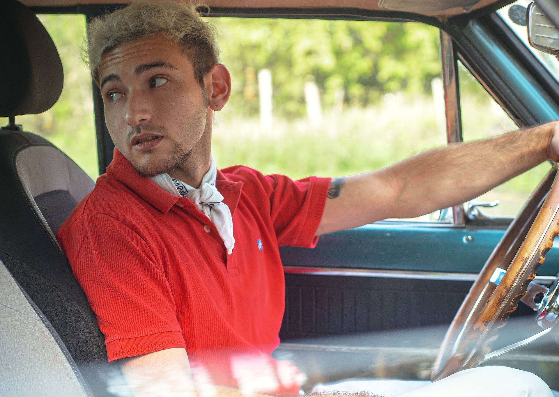 Man in red t-shirt in a car