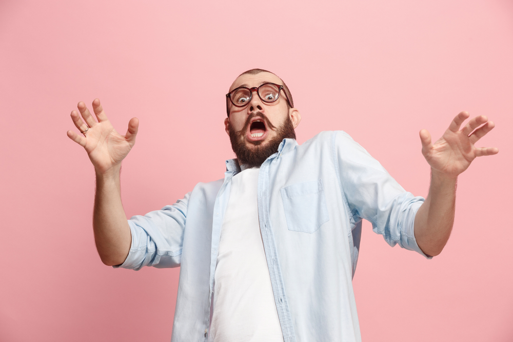 Shocked man in blue shirt and glasses