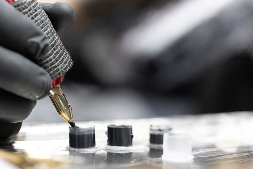 tattooist's hand with black glove holding the tattoo machine