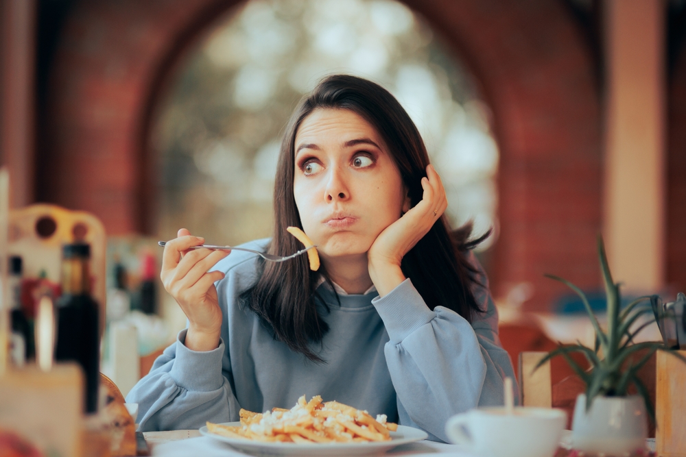 embarrassed woman in blue sweatshirt at  lunch