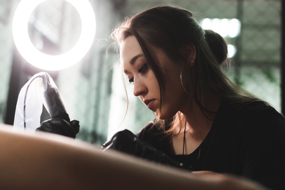 A professional tattoo artist makes a black and white tattoo