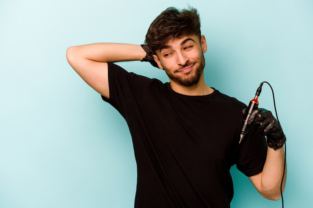 Tattoo artist man in black t-shirt holding a tattoo gun
