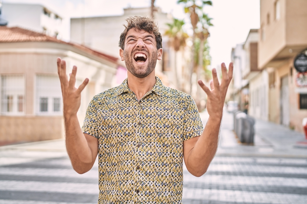 Young man standing at the street  shouting and yelling