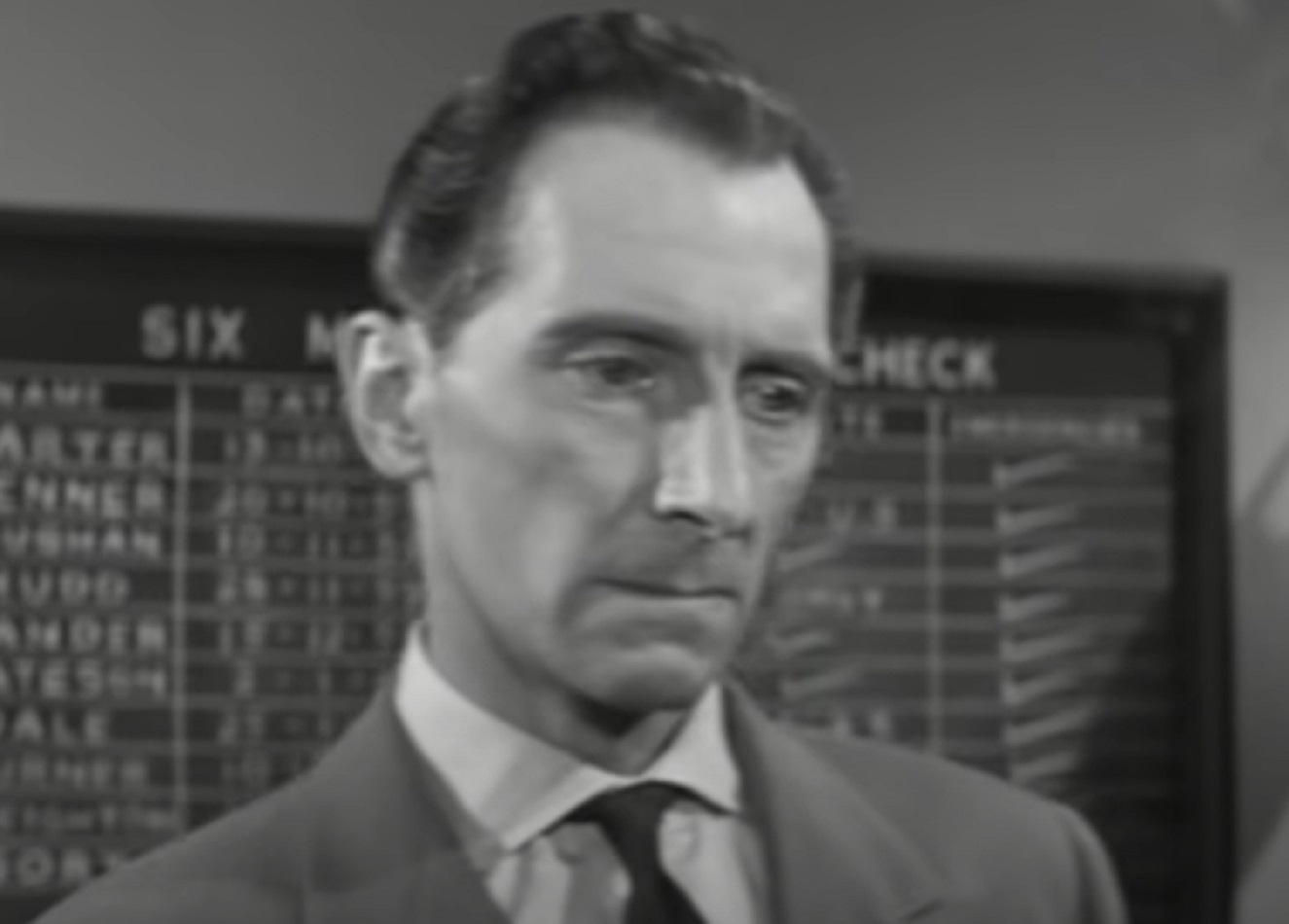 Screenshot of Peter Cushing looking at side with sad face - from Cone of Silence (1960)