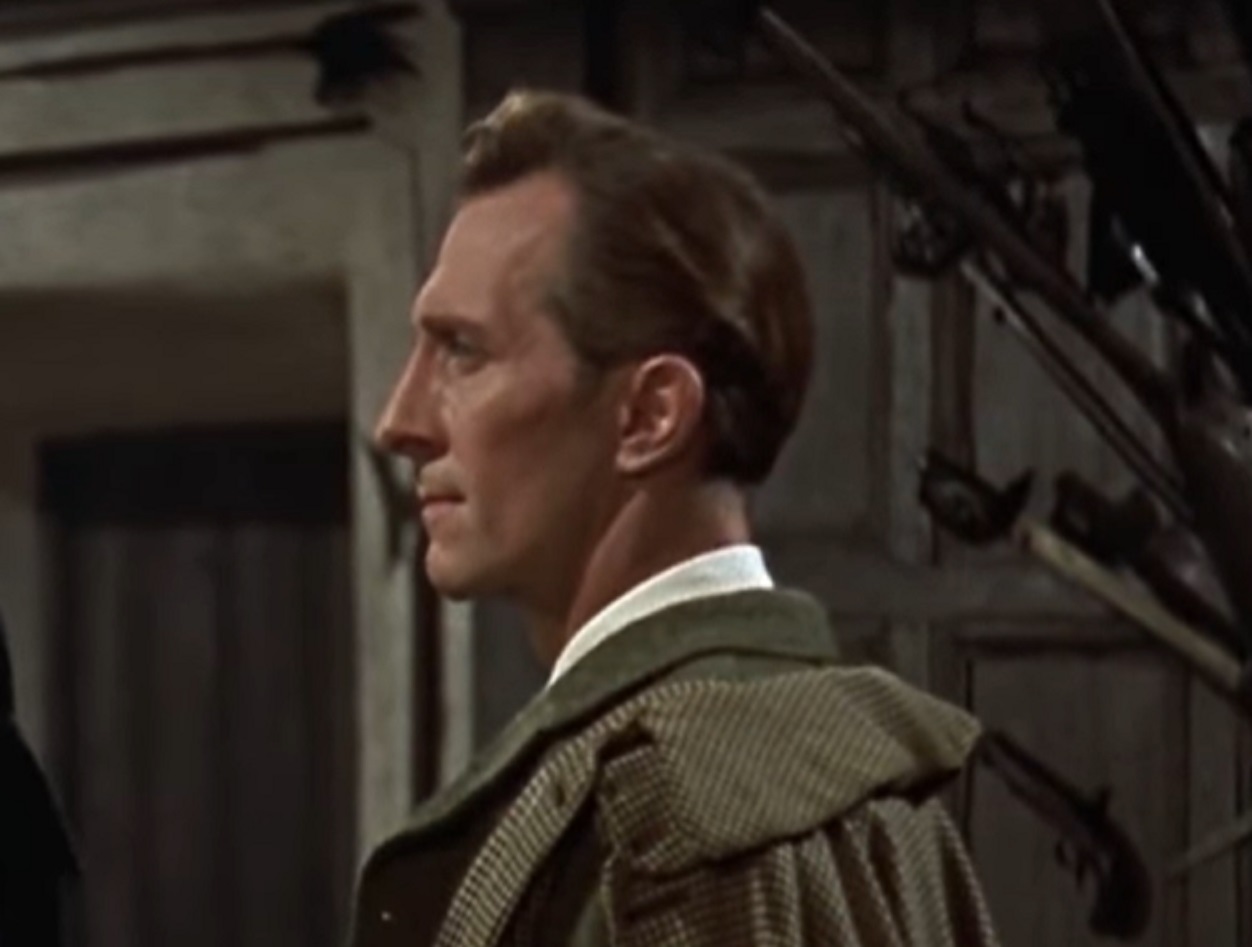 Screenshot of Peter Cushing wearing green coat is looking at front - from The Hound of the Baskervilles (1959)