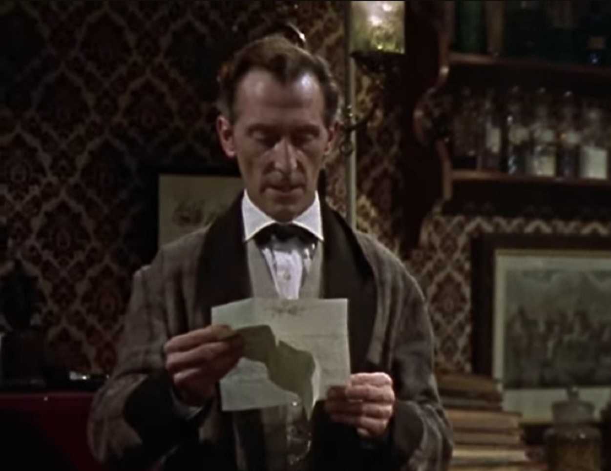 Screenshot of Peter Cushing reading a paper - from The Hound of the Baskervilles (1959)
