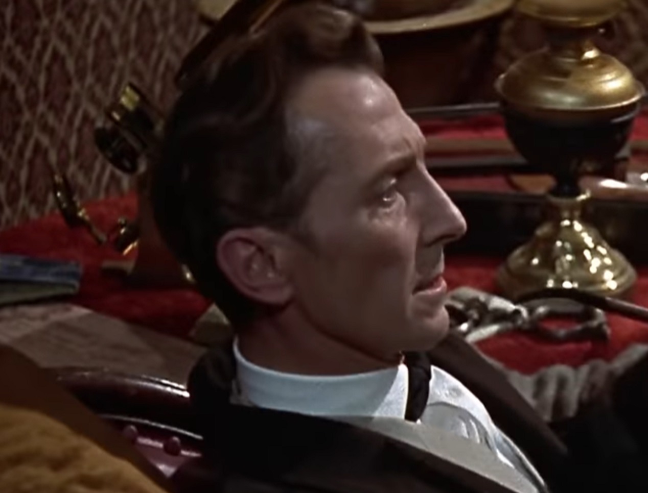 Screenshot of Peter Cushing seating and thinking - from The Hound of the Baskervilles (1959)