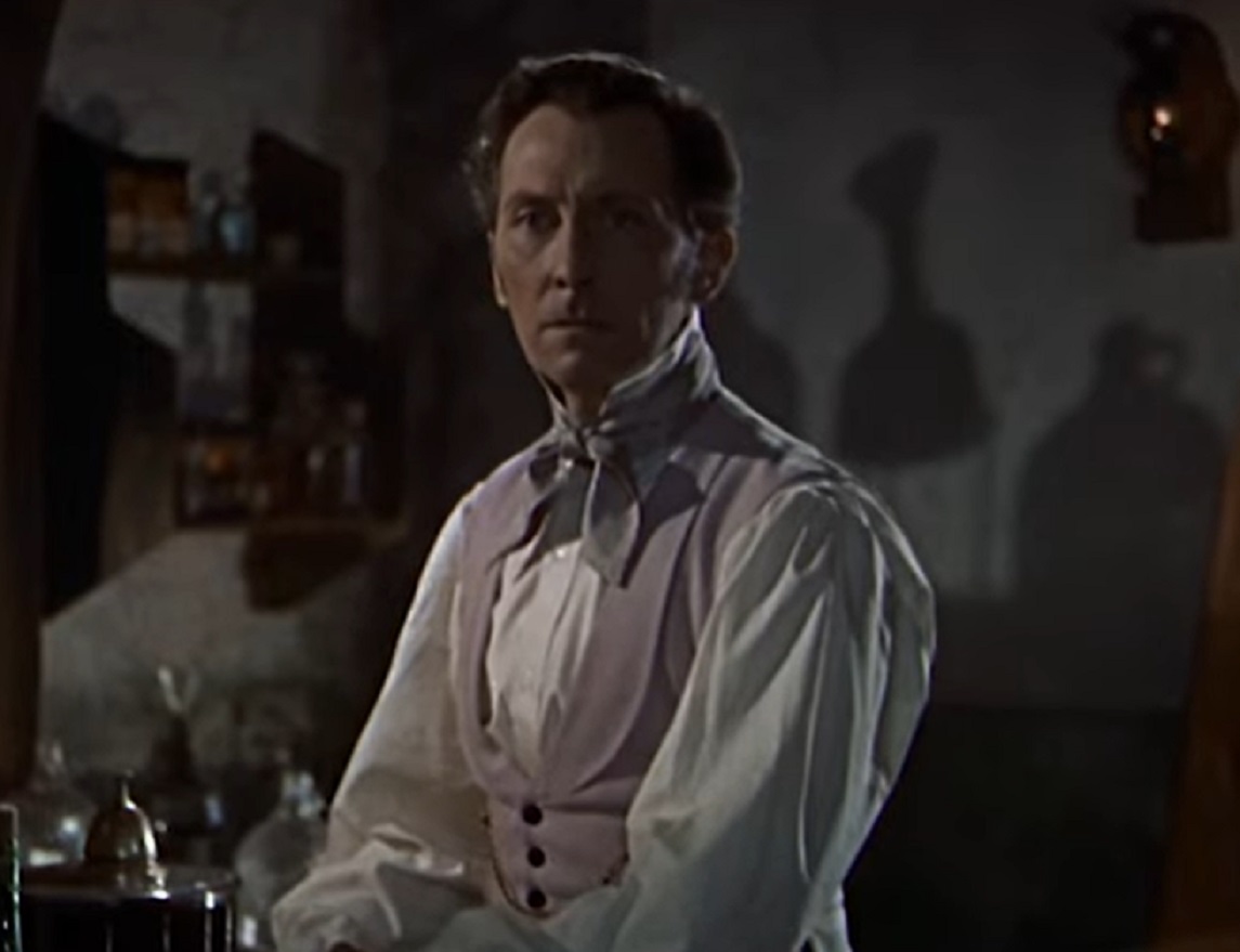 Screenshot of Peter Cushing in white shirt is looking at side - from The Revenge Of Frankenstein (1958)