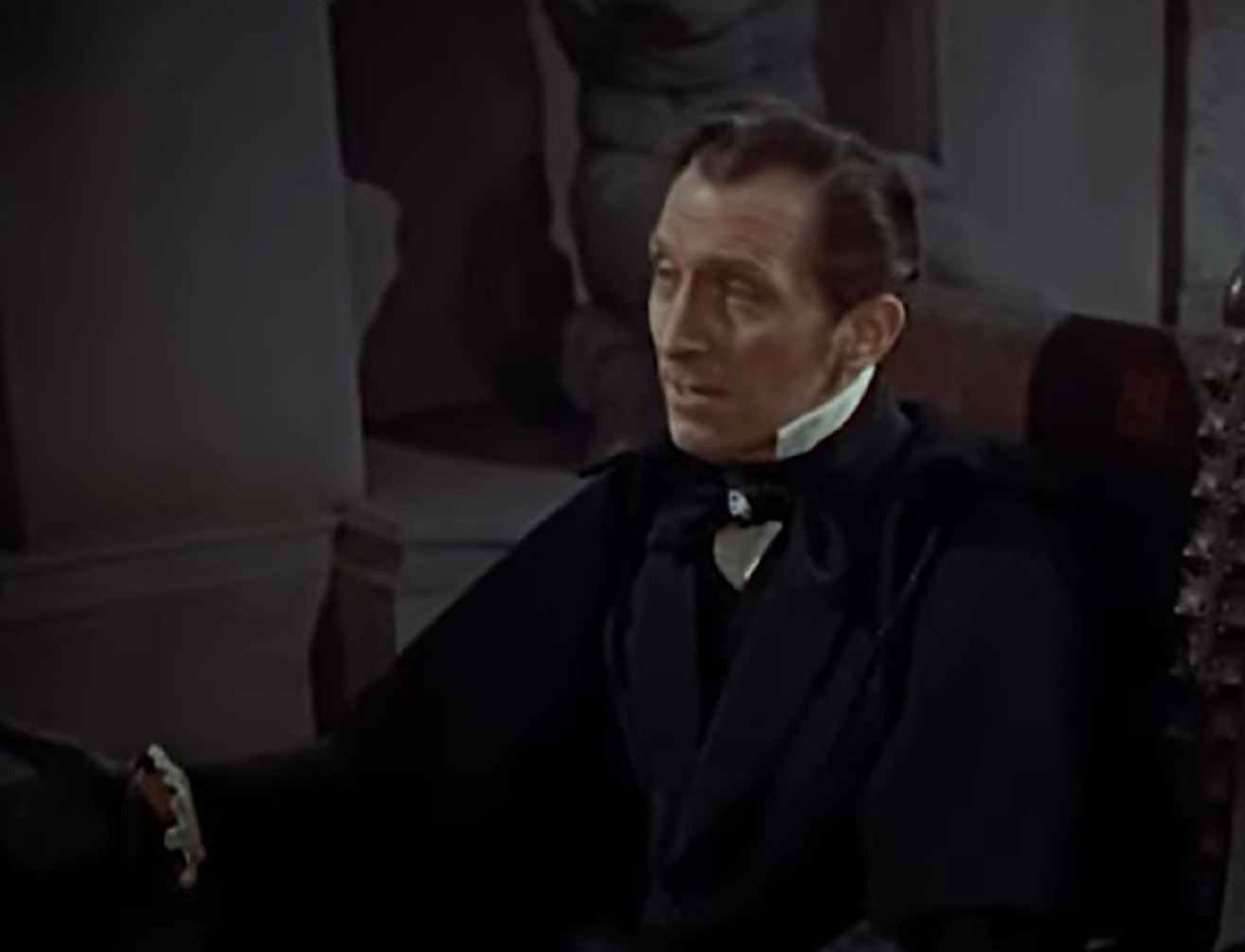 Screenshot of Peter Cushing in black suit is looking at side - from The Revenge Of Frankenstein (1958)