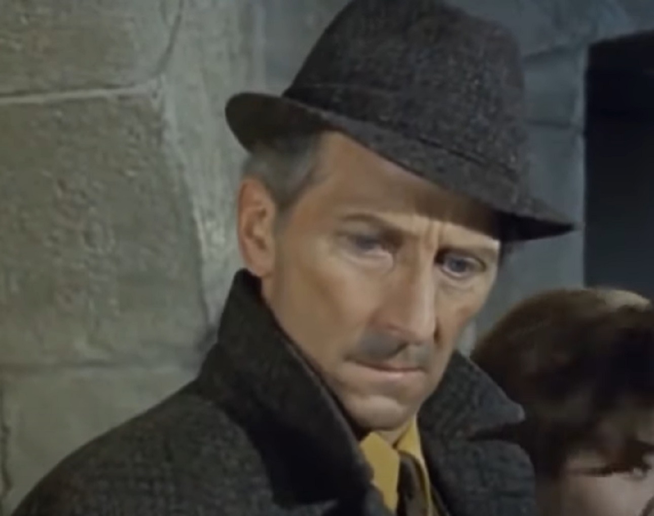 Screenshot of Peter Cushing wearing coat and hat is looking down - from Island of Terror (1966)