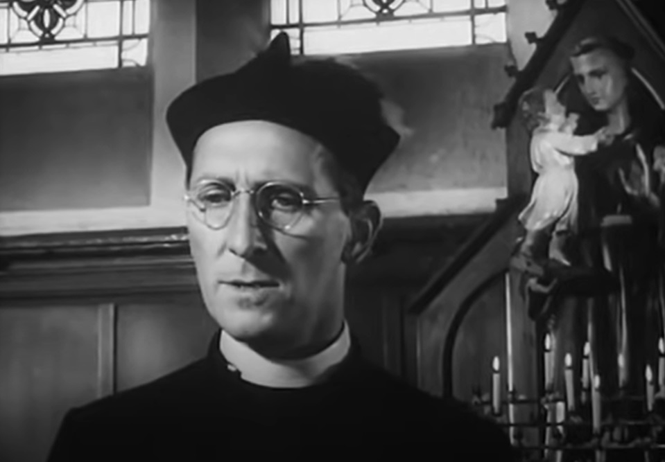 Screenshot of Peter Cushing dressed like a priest - from Violent Playground (1958)