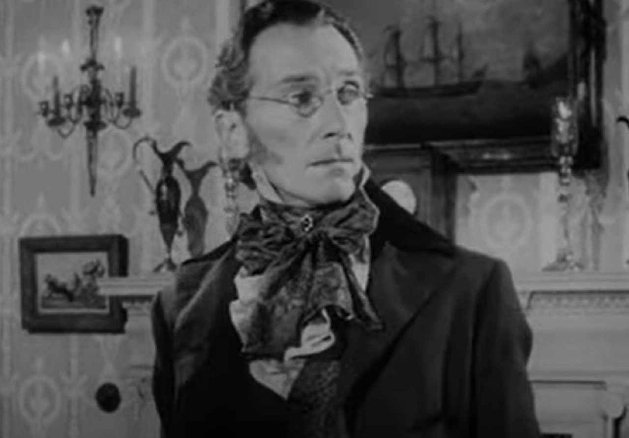 Screenshot of Peter Cushing wearing suit and glasses ,looking at side - from The Flesh and the Fiends (1960)