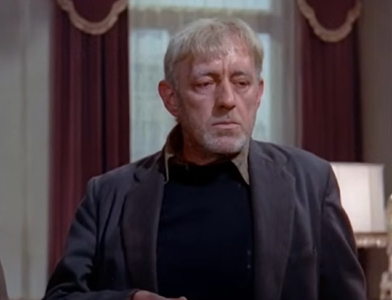Screenshot of Alec Guinness looking at front with sad face - from The Horse S Mouth (1958)