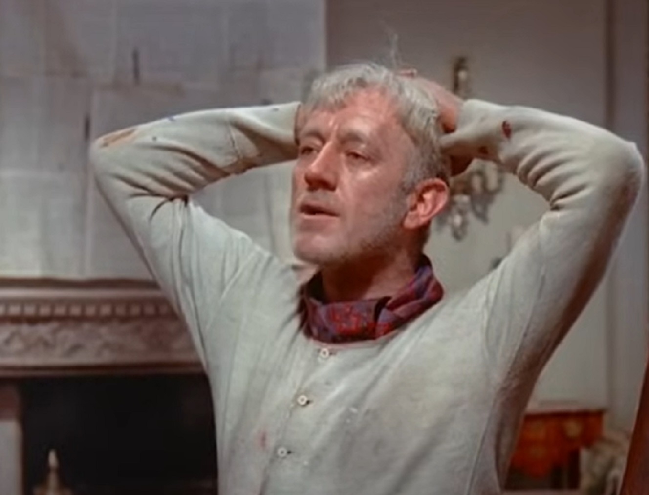 Screenshot of Alec Guinness with arms on his head - from The Horse's Mouth (1958)