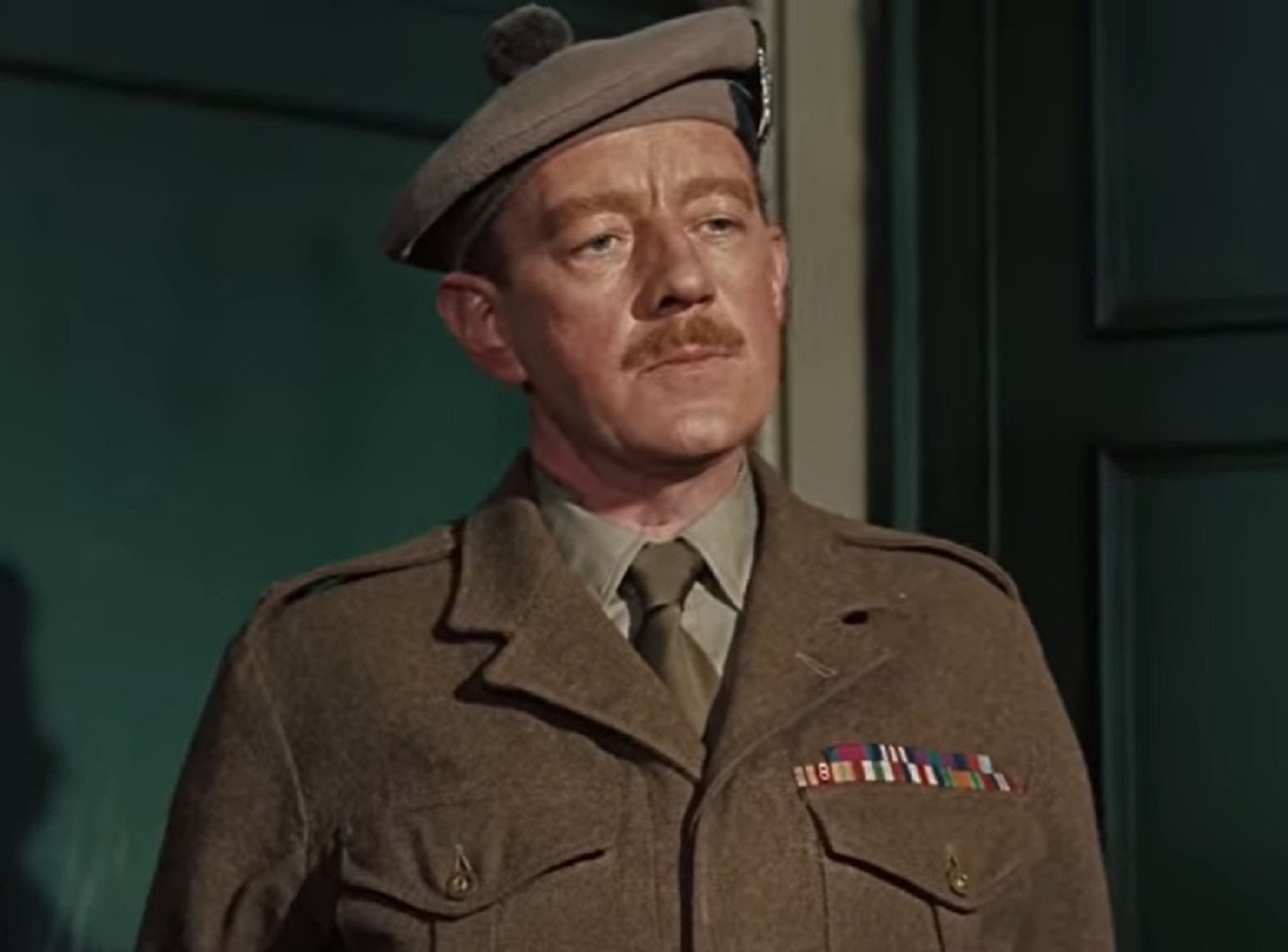 Screenshot of Alec Guinness wearing brown uniform and hat ,looking at front - from Tunes Of Glory (1960)