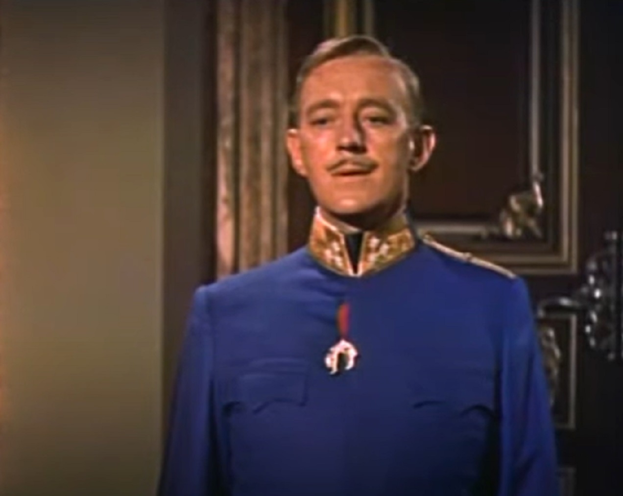 Screenshot of Alec Guinness in uniform looking down - from The Swan (1956)