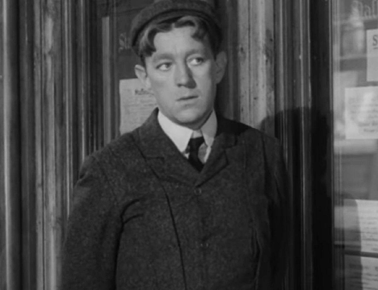 Screenshot of Alec Guinness in black coat is looking at side - from The Promoter (1952)